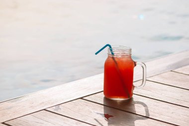 Bardak taze karpuz smoothie meyve suyu içecek yüzme havuzunun sınırında