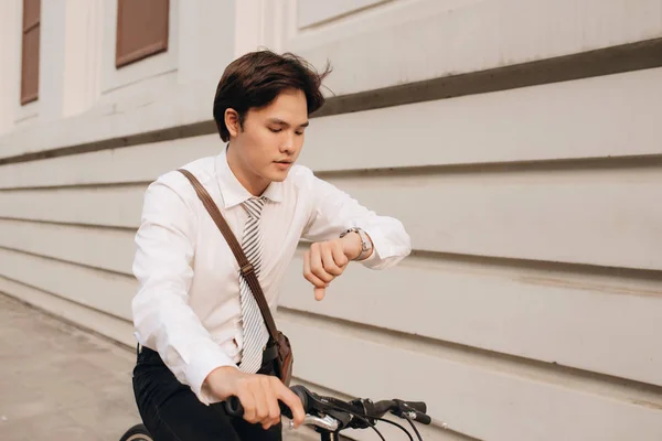 路上で自転車を持つ若いハンサムな男 時計を見て — ストック写真
