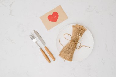aşk akşam yemeği ayar çatal ve kaşık plaka beyaz zemin üzerine kırmızı kurdele ile aşk kravat ve kavram romantizm
