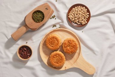Düz ahşap tepsi üzerinde sonbahar ortası festivali gıda mooncakes kavramsal yatıyordu