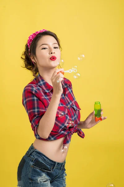 Pin Asya Model Sarı Arka Plan Üzerinde Sabun Köpüğü Üfleme — Stok fotoğraf