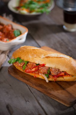 Vietnamca sandviç ekmek köfte domates sosu ve turp, havuç turşusu, salatalık, kişniş ile.