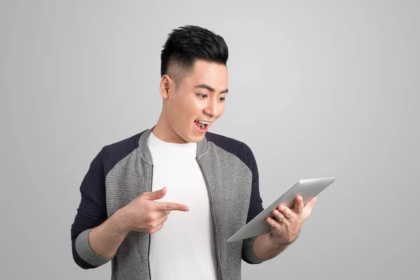 Feliz Asiático Atractivo Joven Hombre Pie Apuntando Tableta Sobre Gris —  Fotos de Stock