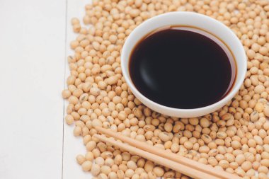 Soya sause ve beyaz arka plan üzerinde soya fasulyesi ile kase