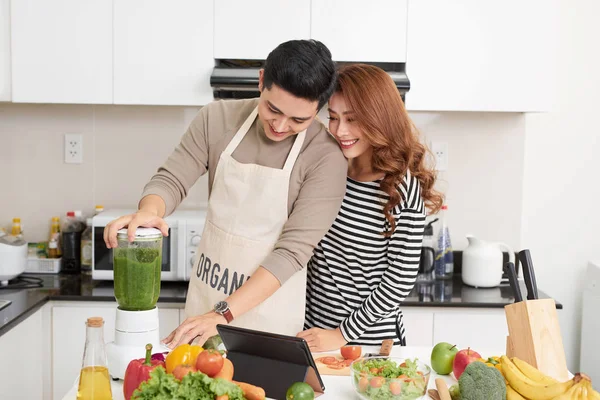 Happy couple cooking in kitchen. Man and woman happy on kitchen cooking.