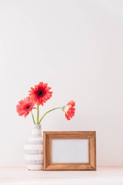Beyaz yatay çerçeve gerbera çerçeve, yanında bir vazo ile sahte yerleşimi teklif, promosyon, başlık veya tasarım, küçük işletmeler, yaşam tarzı blogcular ve sosyal medya kampanyaları için büyük