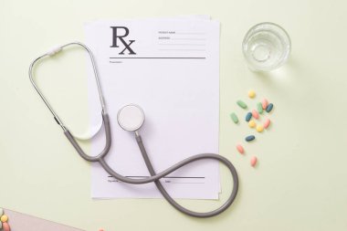 Stetoskop, hap ve açık yeşil renkli su bardak. Tıp kavramı