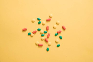 Sarı arka plan üzerinde renkli hapları