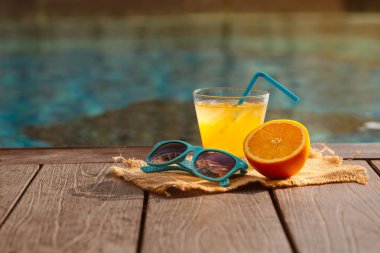 Taze portakal suyu güler yüzlü içki, Yüzme Havuzu yakınındaki güneş gözlüğü