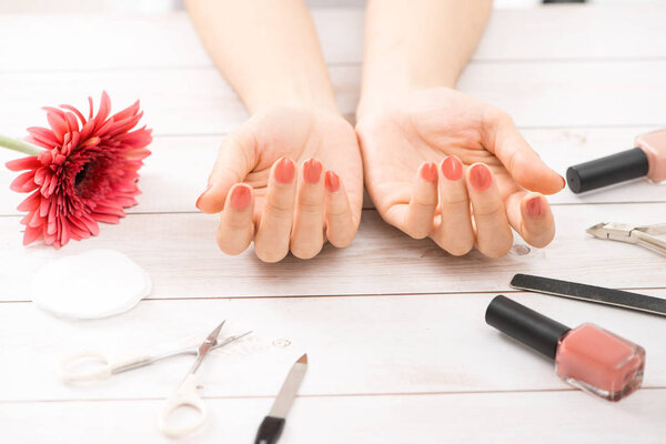 Nail care and manicure. Beautiful female hands with nail polish. Red manicure