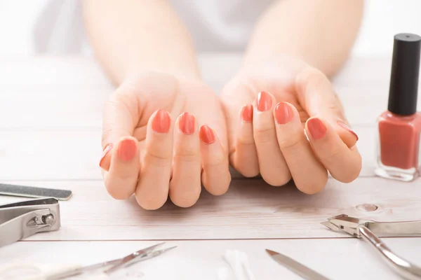 Nail care and manicure. Beautiful female hands with nail polish. Red manicure