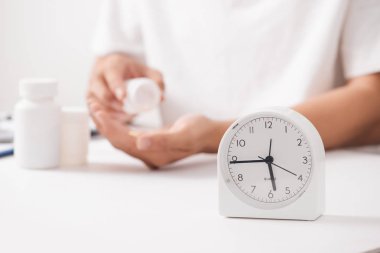 Doktor el bitkisel ilaçlar hap saat ve şişe, tıbbi zaman kavramı ile tutarak