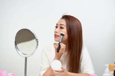 Aynaya bakmak büyük bir fırça ile onun makyaj uygulayarak genç güzel kadın
