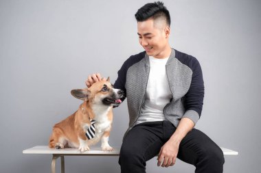 Yakışıklı genç adam köpeğiyle sandalye üzerinde oturan