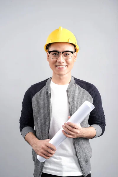 Jovem Arquiteto Masculino Usando Capacete Segurando Plantas Isolado Fundo Cinza — Fotografia de Stock