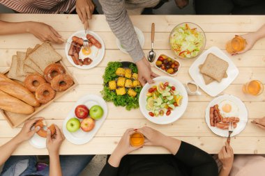 Arkadaşlarınızla akşam yemeği zevk. Grup birlikte ahşap masada otururken yemeğe insan Üstten Görünüm