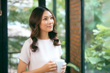 Pencerelerin yanında duran güzel bir kadın. Güzel sabah