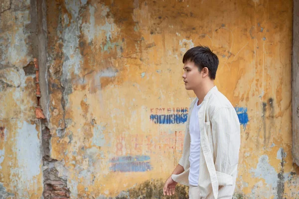 Ασιατική Άνθρωπο Casual Ρούχα Στέκεται Παλιό Τοίχο Φόντο — Φωτογραφία Αρχείου