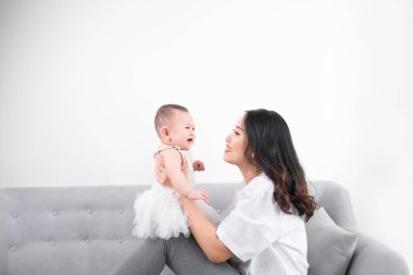 Eski küçük oğlu pijama giymiş onu bir yıl ile Genç Anne rahatlatıcı ve oynarken birlikte hafta sonu oturma odası, tembel sabah, sıcak ve rahat sahne. Seçici odak.