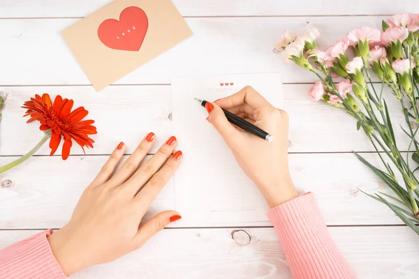 Vrouw Schrijft Liefdesbrief Wit Papier Met Rood Hart Vorm Cijfers — Stockfoto