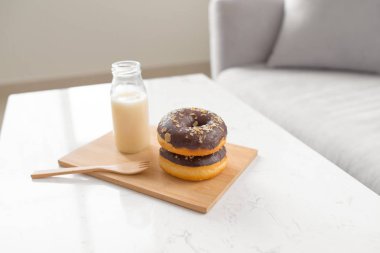 Çikolatalı çörek. Sabah kahvaltısı masada oturma odasında evde süt ile.