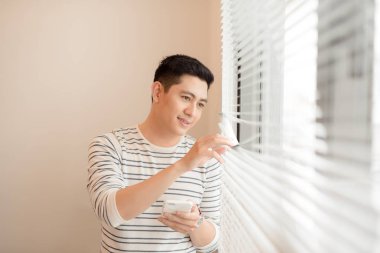 Neşeli delikanlı pencere yaslanmış iken telefon tutarak