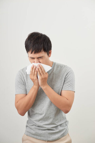 больной человек и чихает на белом фоне, азиатский
