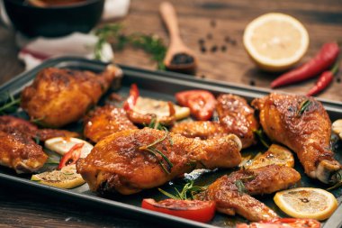 Ahşap masa üzerinde ızgara tavuk ızgara ve fırın tepsisi kanatlarında