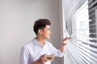 Kahve duran ofis pencere toplantıdan sonra holding beyaz gömlekli kendine güvenen genç işadamı portresi