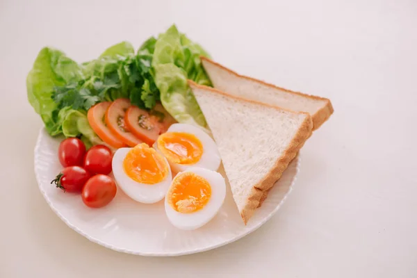 Fresh garden salad with eggs and avocado with tomatoes on plate for healthy low calorie lunch