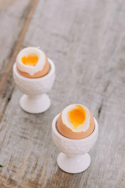 Soft boiled eggs in eggcups on wooden table, Healthy fitness breakfast concept