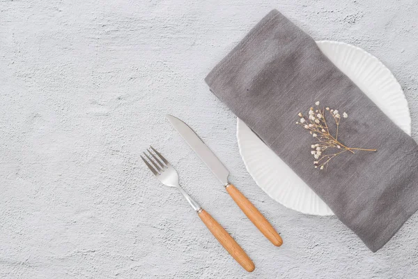 Table prepared for reservation with fork and knife with plate and towel in restaurant