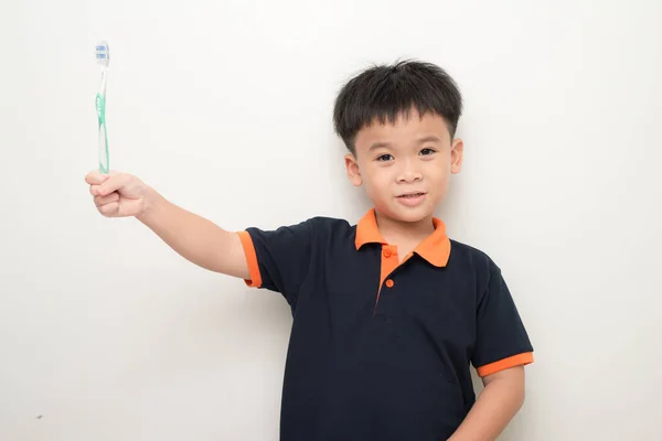 Feliz Niño Sonriente Usando Camiseta Sosteniendo Cepillo Dientes Mientras Posando — Foto de Stock