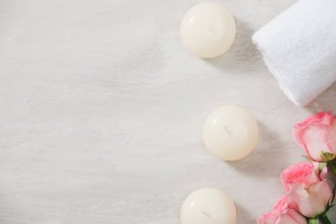 Mumlar ve havlu Spa beyaz yüzeyindeki çiçeklerle