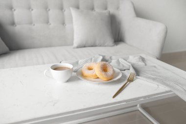 çörek ve kahve fincanı masada oturma odasında evde, sabah kahvaltı konsepti 