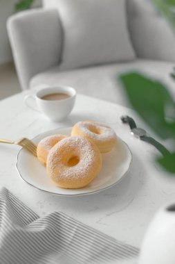 çörek ve kahve fincanı masada oturma odasında evde, sabah kahvaltı konsepti 