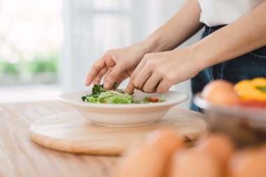 Kadın el koyarak kırpılmış atış marul tabağa kahvaltı için kesmek 