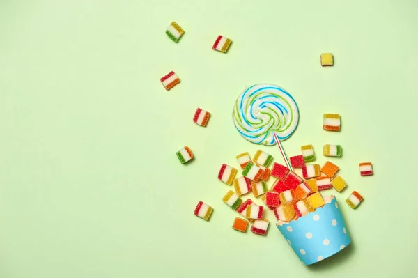 パステル グリーンの背景に様々 な甘いお菓子のトップ ビュー — ストック写真