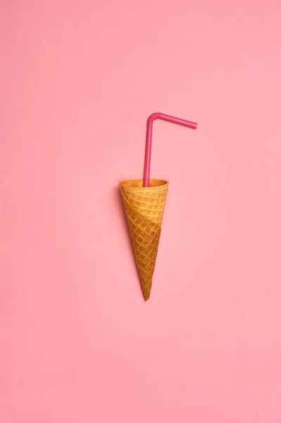 空冰淇淋锥体与秸秆在粉红色背景 — 图库照片