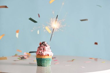 Cupcake mavi arka plan üzerinde üzerinde tek maytap