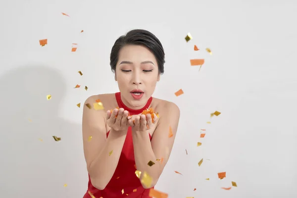 Ung Asiatisk Kvinna Blåser Konfetti Luften Ljus Bakgrund — Stockfoto