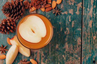 Elma çayı tarçın çubuğu ile sıcak içecek. Cam malzemelerle rustik ahşap tablo