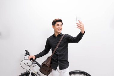 Asya adam bisiklet ve alma selfie Smartphone cep telefonu ile yakın ayakta 