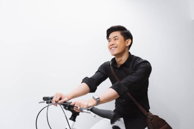 Beyaz arka plan üzerinde bisiklet üzerinde oturan genç Asyalı adam