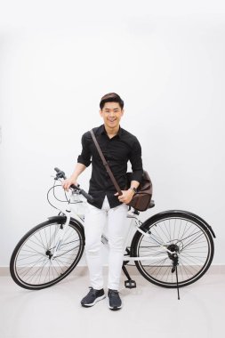  genç şık Asya adam beyaz arka plan üzerinde bisiklet yanında poz