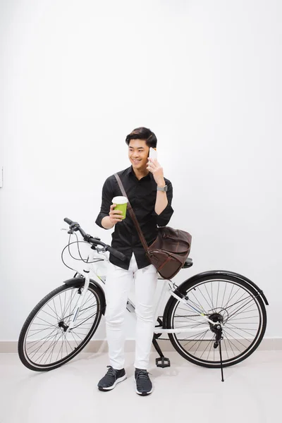 Молодой Азиат Стоящий Рядом Велосипедом Пьющий Кофе Разговаривающий Смартфоне — стоковое фото