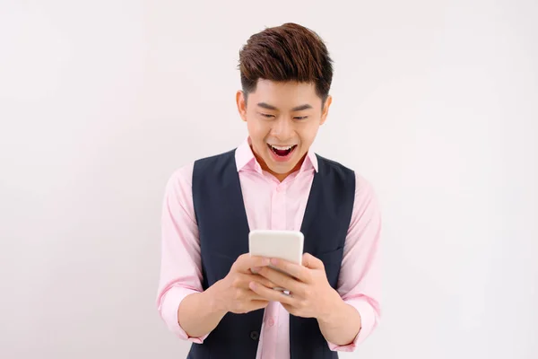 Młody Człowiek Azjatyckich Stojących Jasnym Tle Przy Użyciu Smartfona — Zdjęcie stockowe