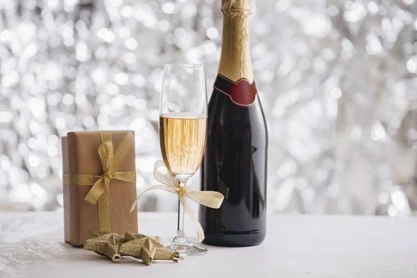 シャンパン グラスとシルバーのキラキラ背景にギフト ボックスとクリスマス飾り瓶 — ストック写真