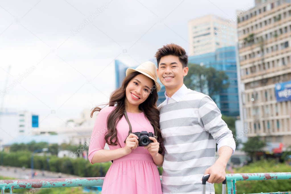 Happy young asian couple traveling in city