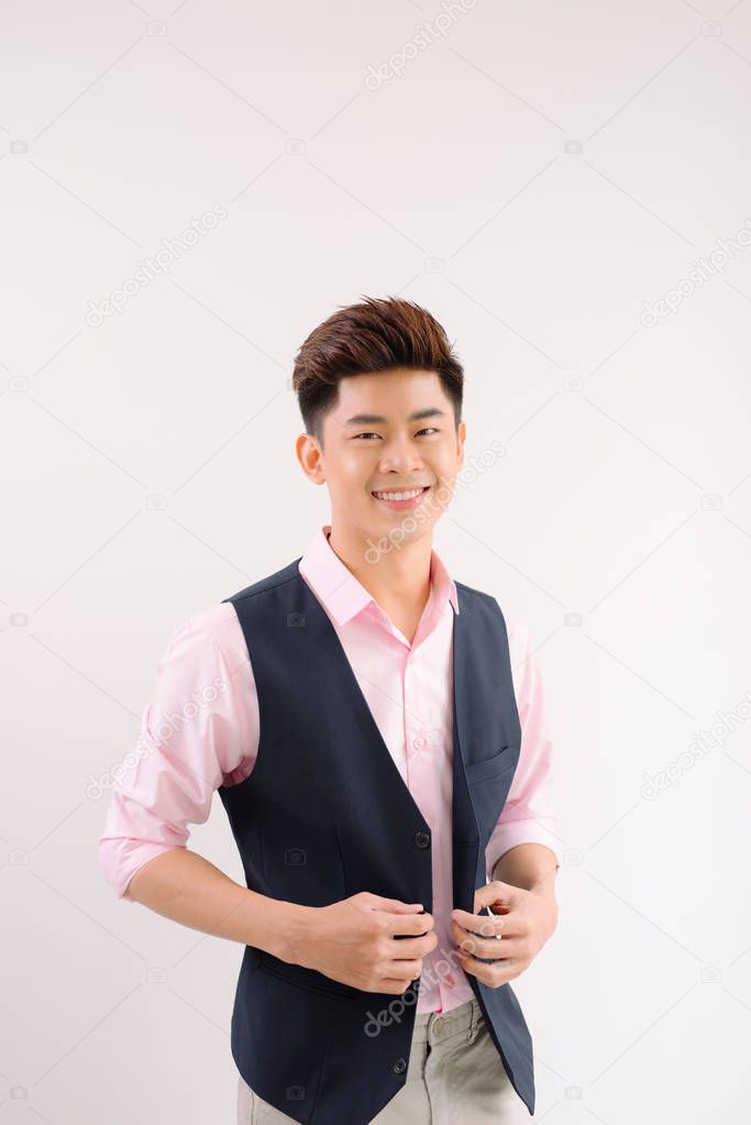 Smiling asian man standing and posing on gray background